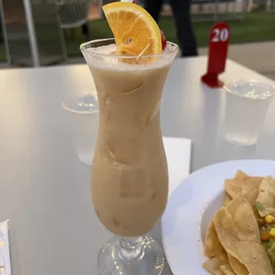 a drink and nachos on a table