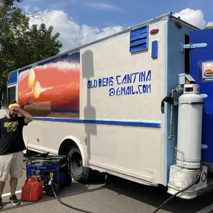 man standing next to a food truck