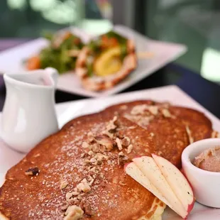 a plate of pancakes and a bowl of fruit