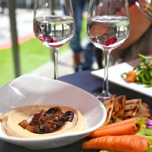 a plate of food and two glasses of wine