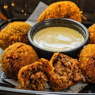 a plate of fried meatballs with dipping sauce