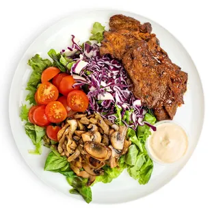 a plate of meat, vegetables, and sauce