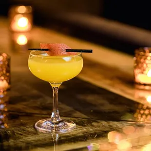 a yellow cocktail with a garnish garnish garnish garnish garnish garnish