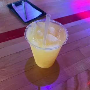 a drink in a plastic cup on a wooden table