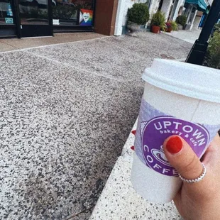 a hand holding a cup of coffee