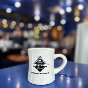 a white coffee cup on a blue table