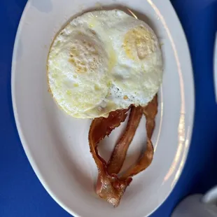 an egg and bacon on a plate