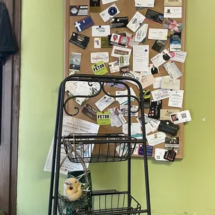 a cart with items on it in front of a bulletin board
