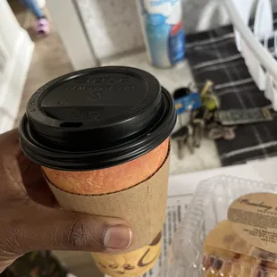 a hand holding a cup of coffee