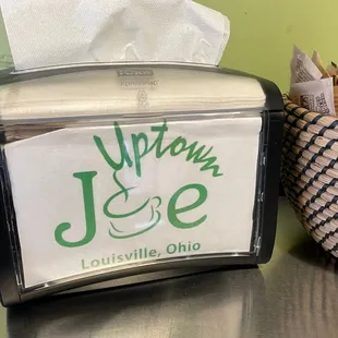 a napkin dispenser and a basket of pencils