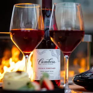 two glasses of wine and a plate of cheese