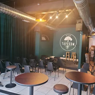 tables and stools in front of a green wall