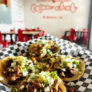 three tacos on a checkered plate