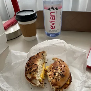 a half eaten bagel and a cup of water