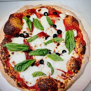 a pizza with olives and mozzarella