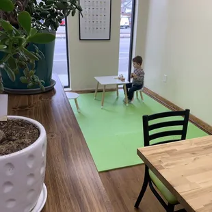 a child sitting in a chair on a green mat