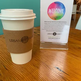 a cup of coffee and a welcome sign