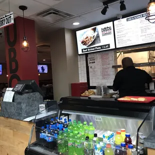 ows a man in a black jacket standing at the counter