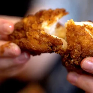  hand holding a fried chicken