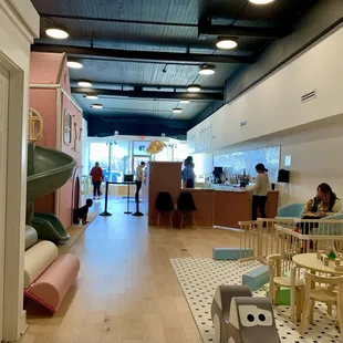 View from the restrooms of the west wing of space, including the play area and counter.