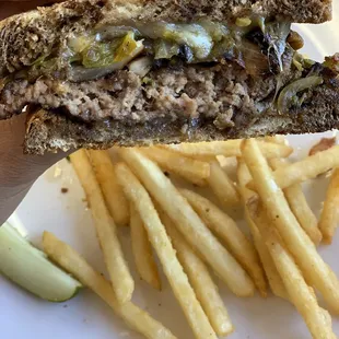 Patty melt with mushroom, grilled onions, green Chile, Swiss, on rye bread.
