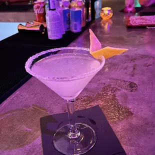 a martini with a lemon wedge on the rim