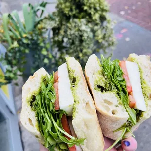 a person holding a sandwich in their hand