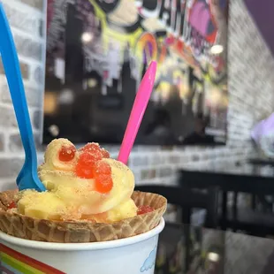 Pineapple dole whip, strawberry popping boba and graham crackers in a waffle cone.