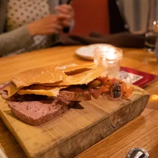 a meat and cheese sandwich on a cutting board