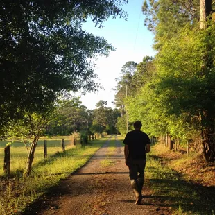a man walking down a dirt road