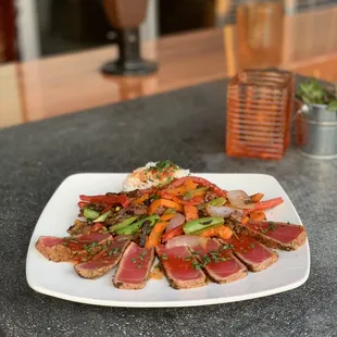 Seared blackened ahi, basmati rice and stir fry vegetables with a sweet chili garlic sauce.