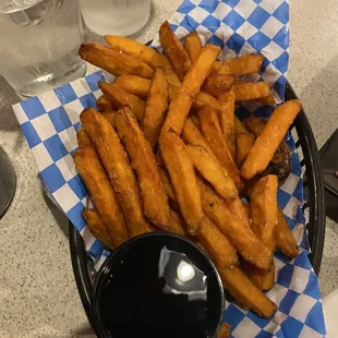 a basket of french fries with a side of ketchup