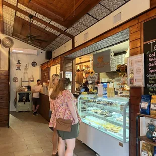 a woman standing in front of a bakery