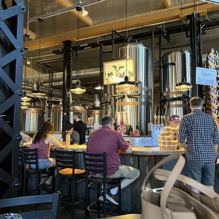 people sitting at tables in a brewery
