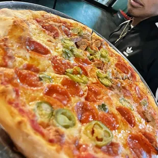 a man sitting at a table with a pizza