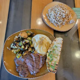 Grass-fed steak, organic garlic mashed potatoes w/gravy, garlic bread, brussels sprouts, rice pilaf, and garlic bread.