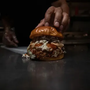 a person placing a hamburger on a counter