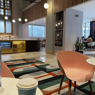 a coffee cup on a table with a laptop on it