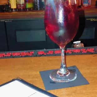 a drink in a wine glass on a bar