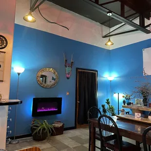 a dining room with blue walls and a fireplace