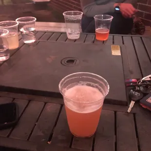 a beer in a plastic cup on a table