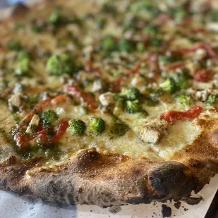 a pizza with broccoli and tomatoes