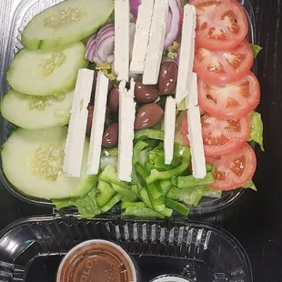 a plastic container containing a salad