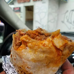 a hand holding a burrito
