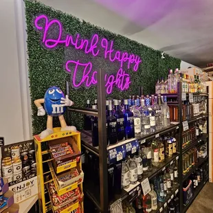 a shelf of liquor bottles and a neon sign