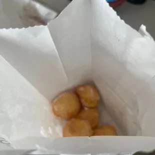 a white paper bag filled with doughnuts