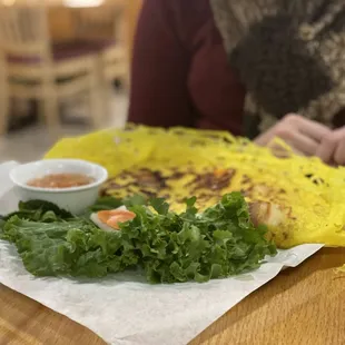 a person sitting at a table with a plate of food