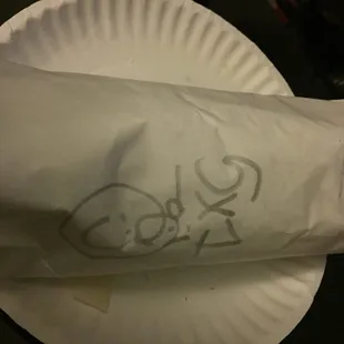 a paper plate with a sandwich on it