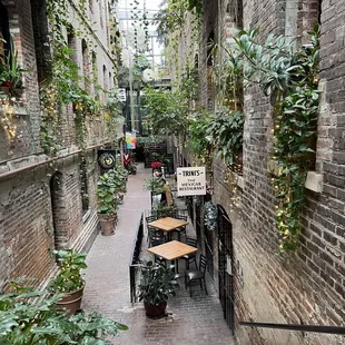 a narrow alley with tables and chairs