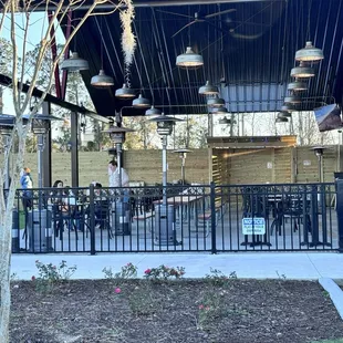 Outdoor area with space heaters and picnic tables,